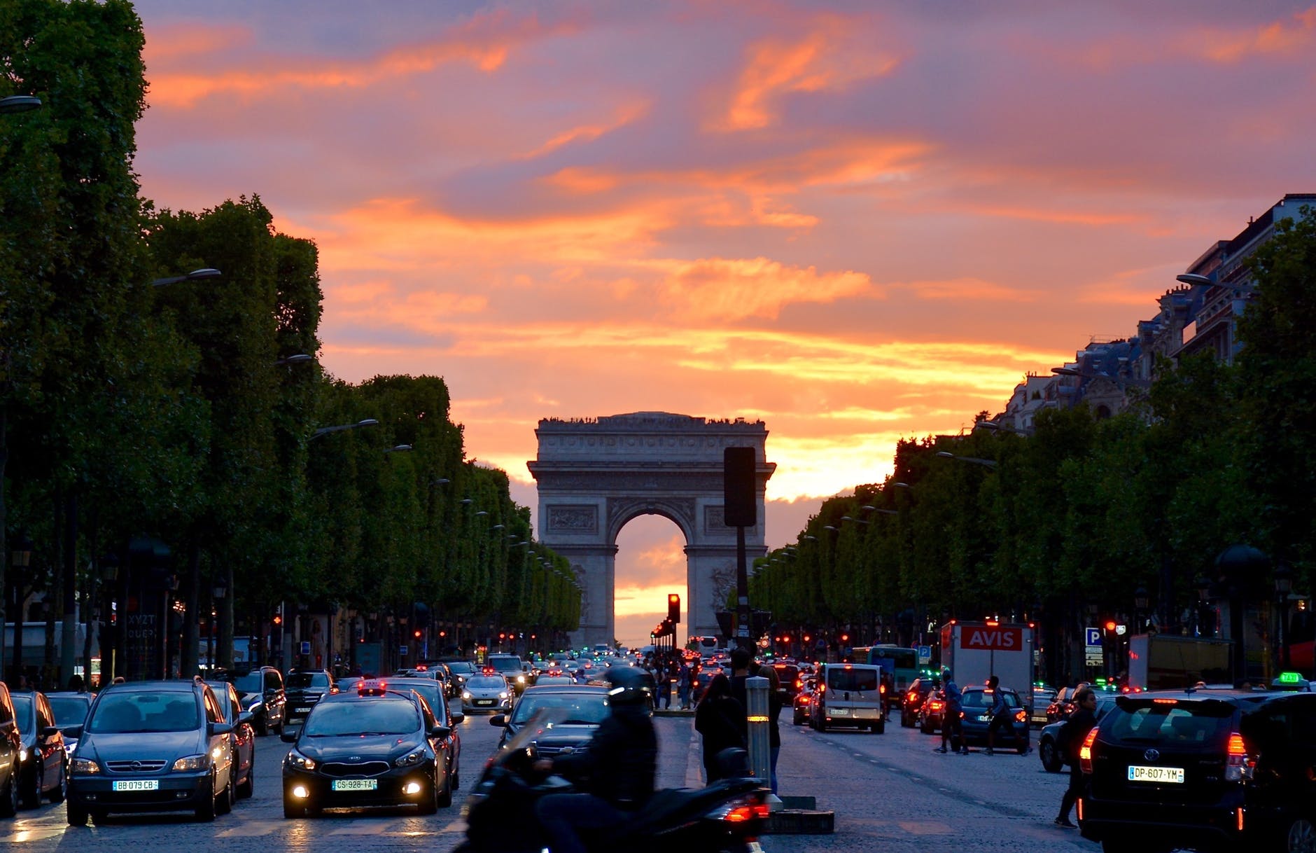 crowded street with cars along arc de triomphe